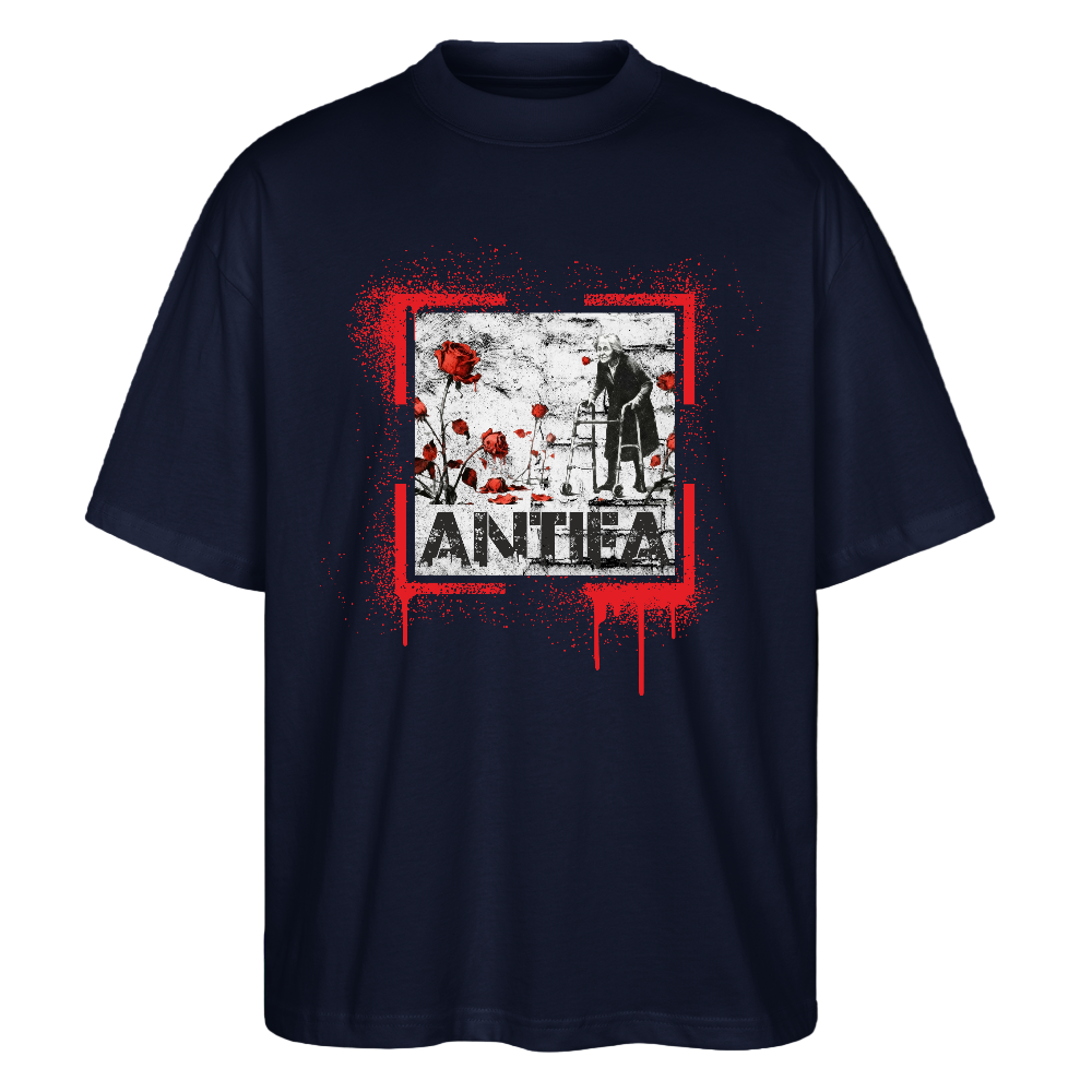 Navy Frontansicht Oversized T‑Shirt: roter Paint‑Splatter Rahmen um ein monochromes Motiv einer Person am Rollator, verteilt rote Rosen und großer „ANTHEA“ Schriftzug darunter; Stanley/Stella Bio‑Unisex.