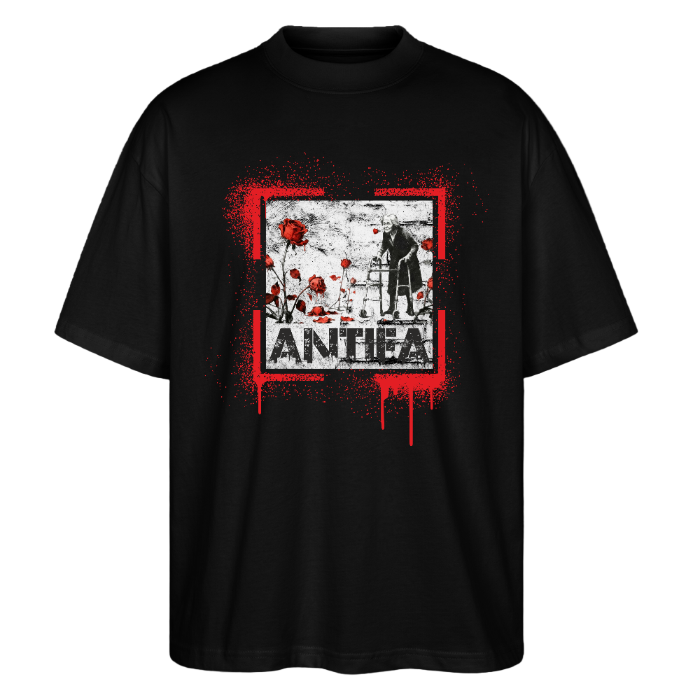 Stanley/Stella Oversized Unisex Bio T-Shirt Blaster - Schwarz Schwarzes Shirt mit rotem Paint‑Splatter, älterer Person am Rollator und roten Rosen; darunter ANTIFA