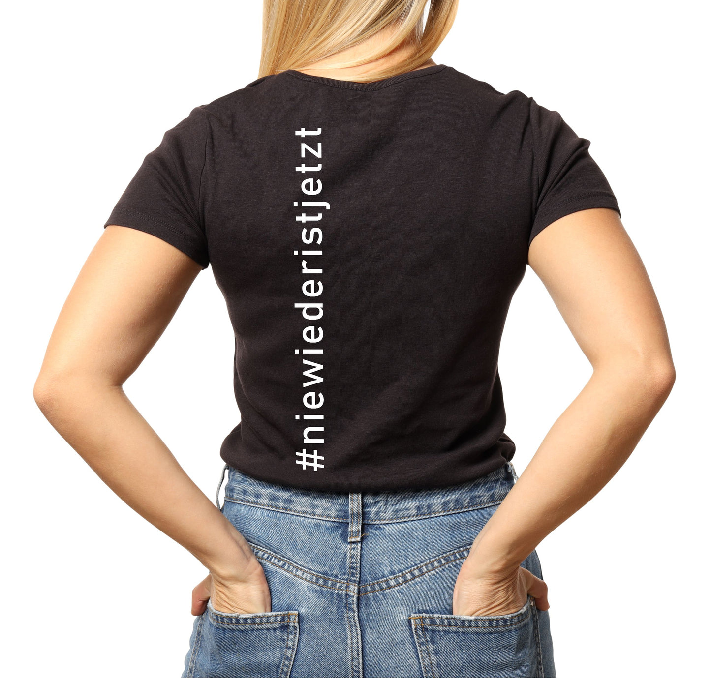 Frau trägt ein schwarzes T-Shirt mit weißem Print „Nie wieder ist jetzt“ auf dem Rücken; aufgenommen vor hellem Hintergrund. Das Shirt besteht aus Bio-Baumwolle und besitzt einen klassischen Rundhalsausschnitt. Der Schriftzug ist hochwertig im Siebdruckverfahren aufgebracht und symbolisiert eine klare antifaschistische Haltung.