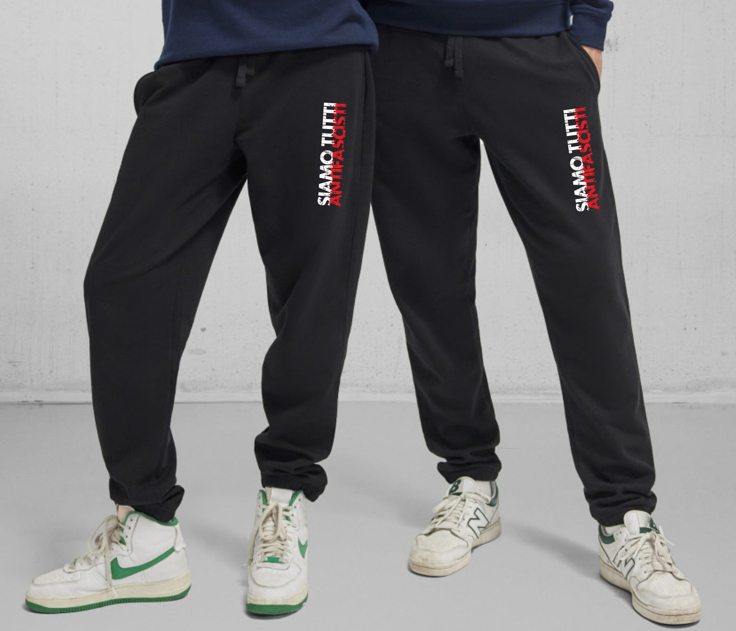 Schwarze Unisex-Jogginghose mit weißer Aufschrift „Siamo tutti antifascisti“ vorne. Fotografiert vor neutralem Hintergrund