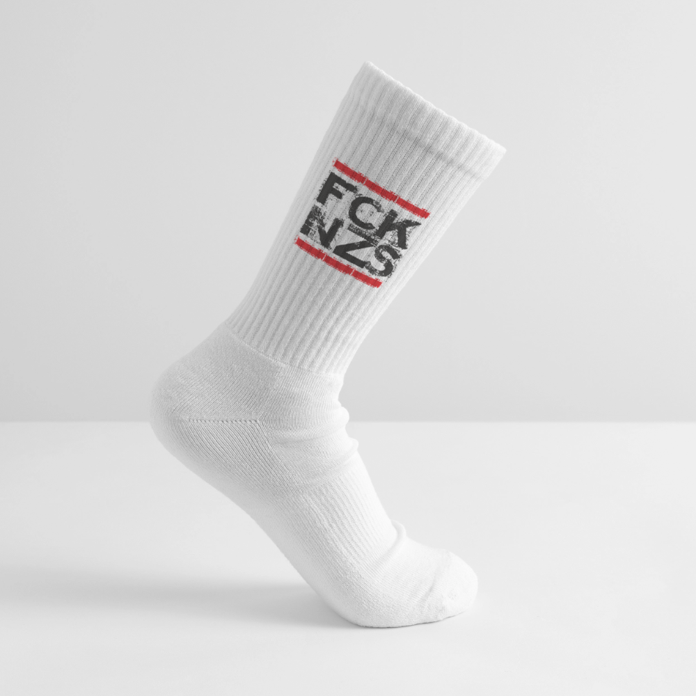 Weiße Tennissocke mit schwarzem „FCK NZS“ Print und roten Balken. Gerippter Schaft, elastisches Bündchen, getragen auf weißem Hintergrund.