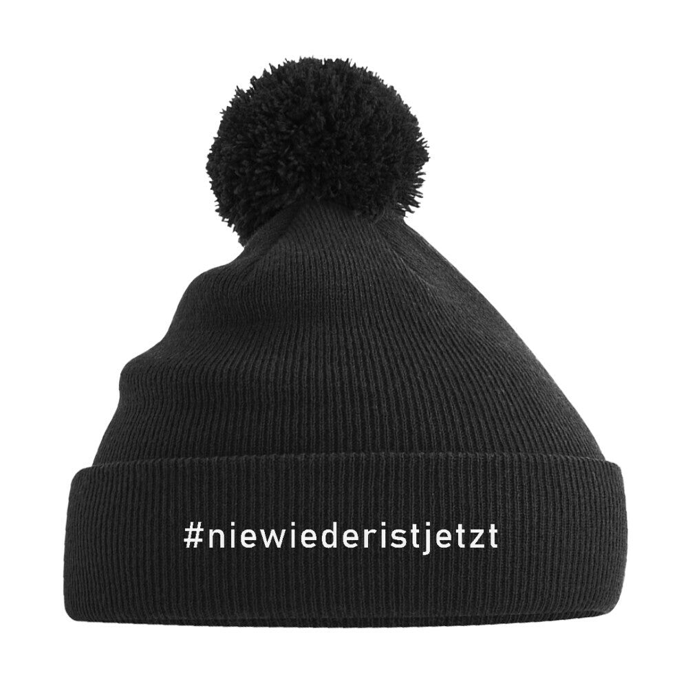 Schwarze Strickmütze mit weißem Aufdruck #niewiederistjetzt und Pompon – aktivistisches Winteraccessoire