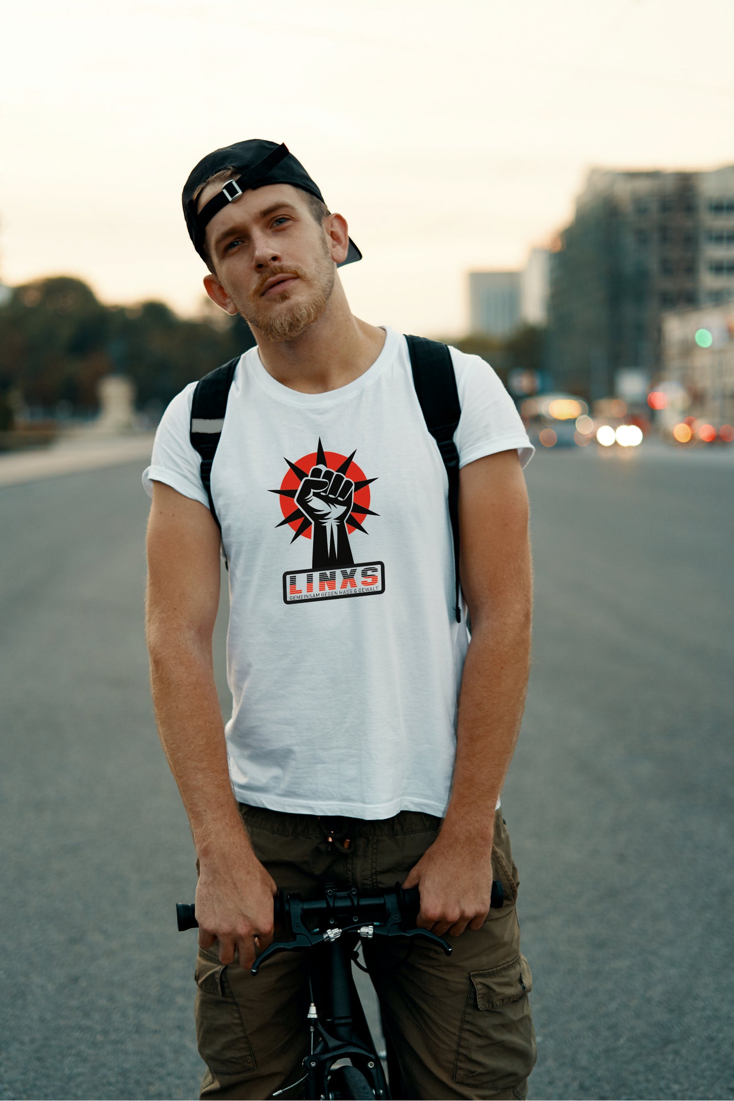 Mann auf Fahrrad trägt weißes Shirt mit dem Aufdruck LINKS