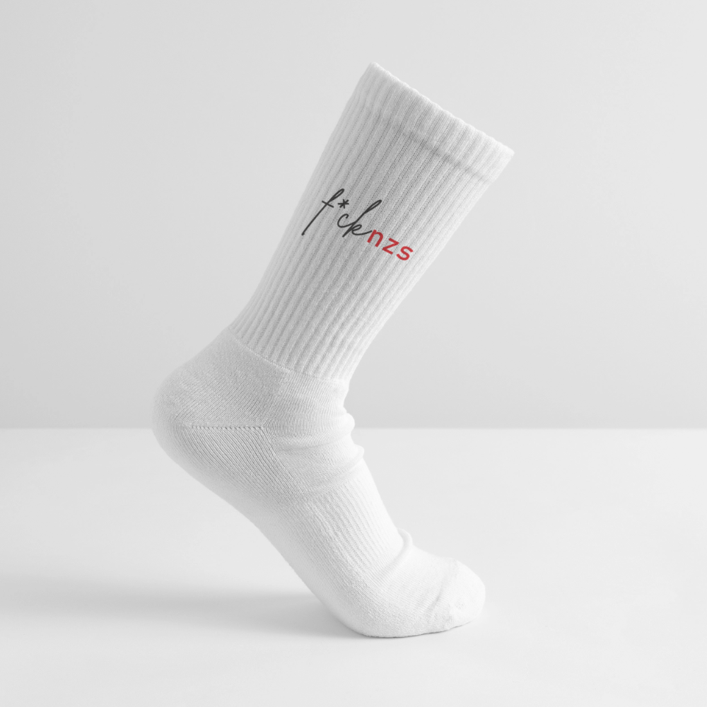 Weiße Tennissocke mit schwarzem „F*ck“ und rotem „NZS“ Print. Gerippter Schaft, elastisches Bündchen, getragen auf weißem Hintergrund.