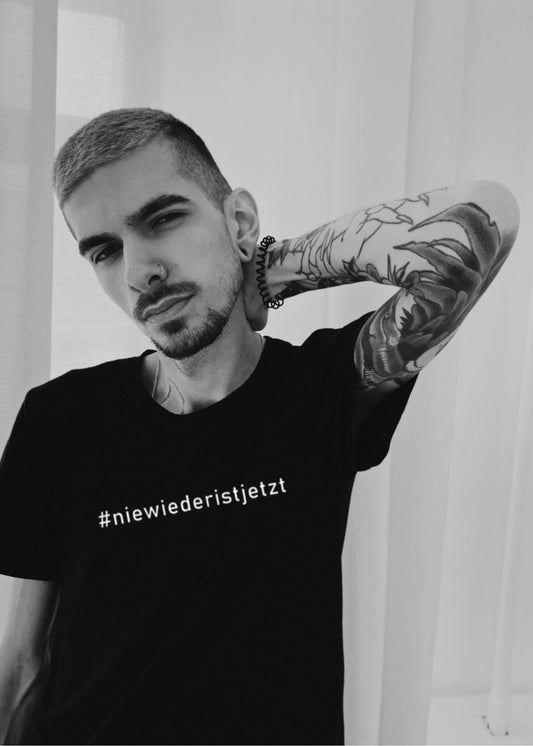 Unisex-T-Shirt mit dem Aufdruck „Nie wieder ist jetzt“, fair produziert aus Bio-Baumwolle, in Schwarz oder Weiß. Hochwertiger Siebdruck auf Vorder- und Rückseite